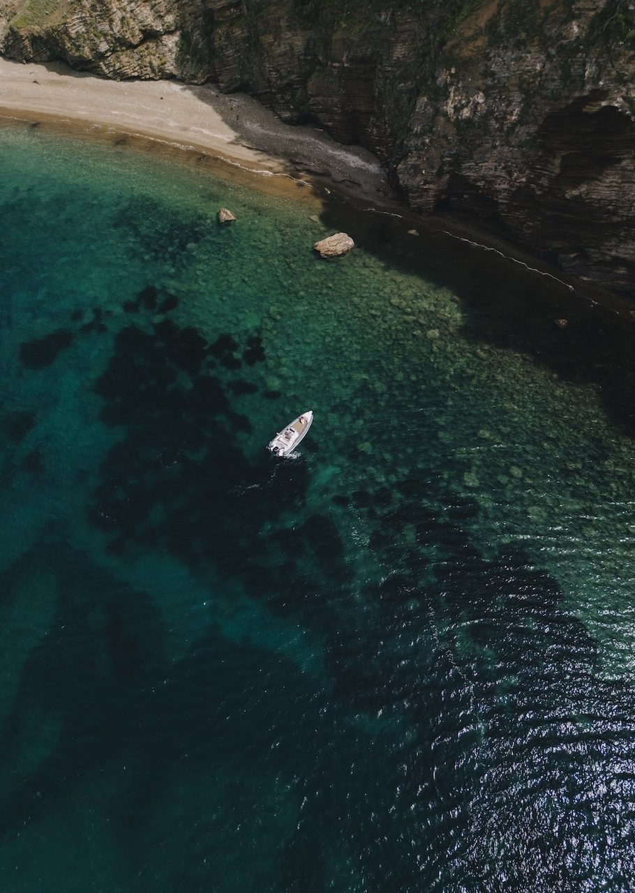 Vista aerea di una caletta nascosta con spiaggia e falesia stratificata dell'Isola d'Elba