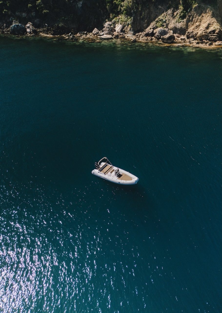 Vista aerea di un gommone Rent Boat Bagnaia fermo davanti a una caletta rocciosa dell'Isola d'Elba